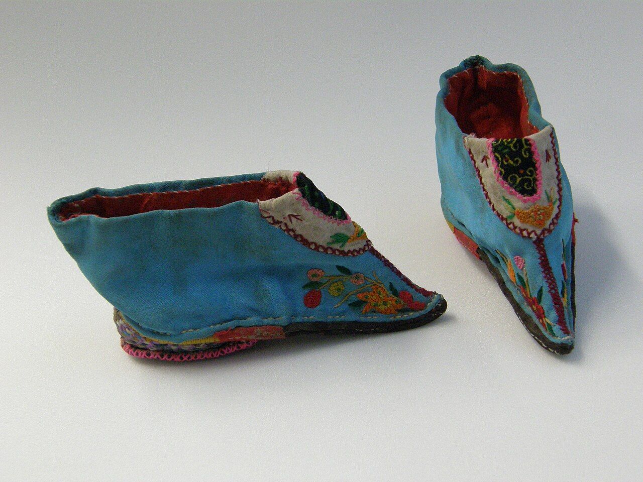 Pair of bound feet shoes from Qing dynasty China displayed in a museum case
