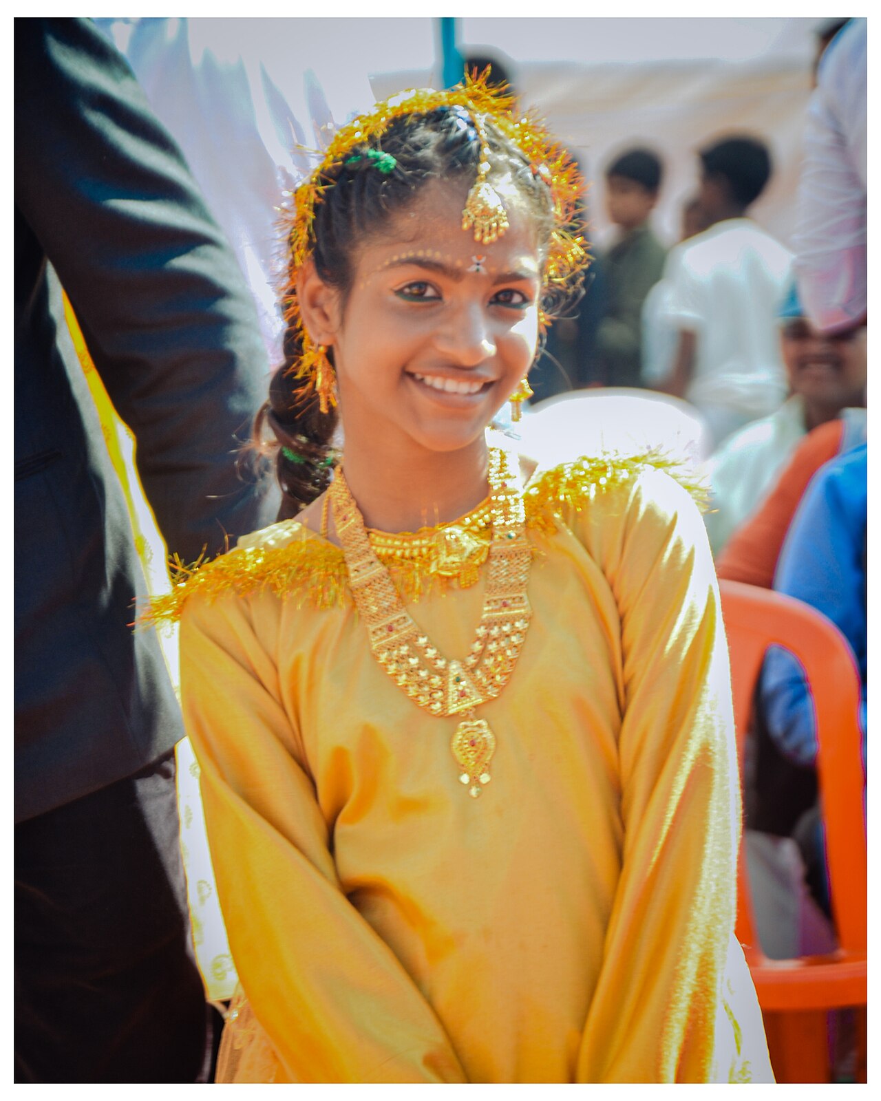A person in traditional attire and jewelry at a cultural celebration