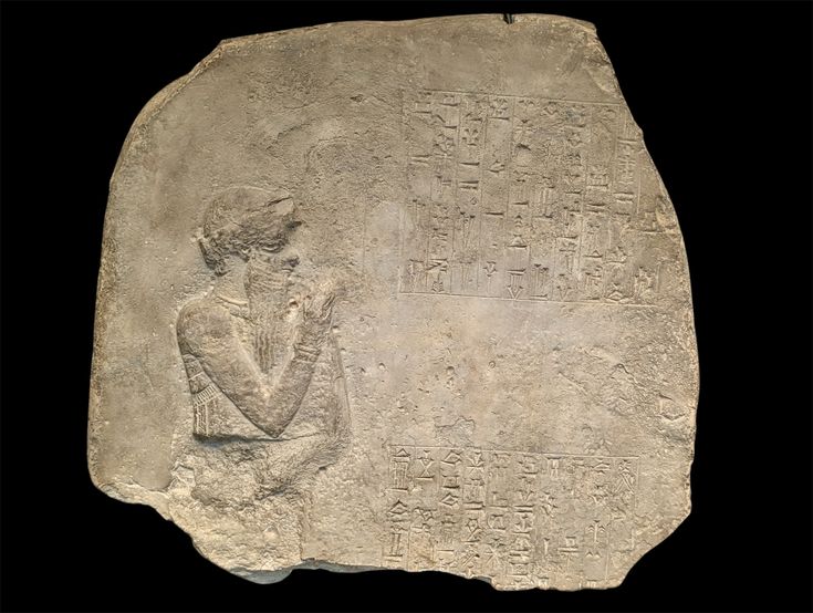 The upper portion of the black diorite stele of Hammurabi, showing the standing king facing the seated sun god Shamash who extends a rod and ring, above dense columns of cuneiform text